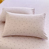 A beige floral printed pillow cover resting on a white surface.