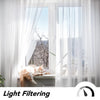 White sheer tulle curtains filter natural light through a window, illuminating a cat resting nearby.