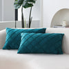 Two teal velvet decorative pillow covers resting on a white sofa.