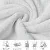A soft white throw blanket is tightly rolled, showing its fluffy texture and drape.
