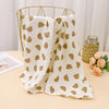 A beige printable cotton crib sheet with a pattern of small brown bears is draped over a gold wire hanger.