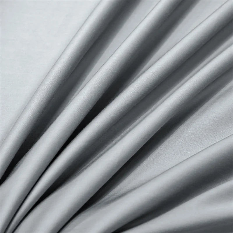 Soft gray luxury bamboo flat sheets draped and folded, showing fabric texture.