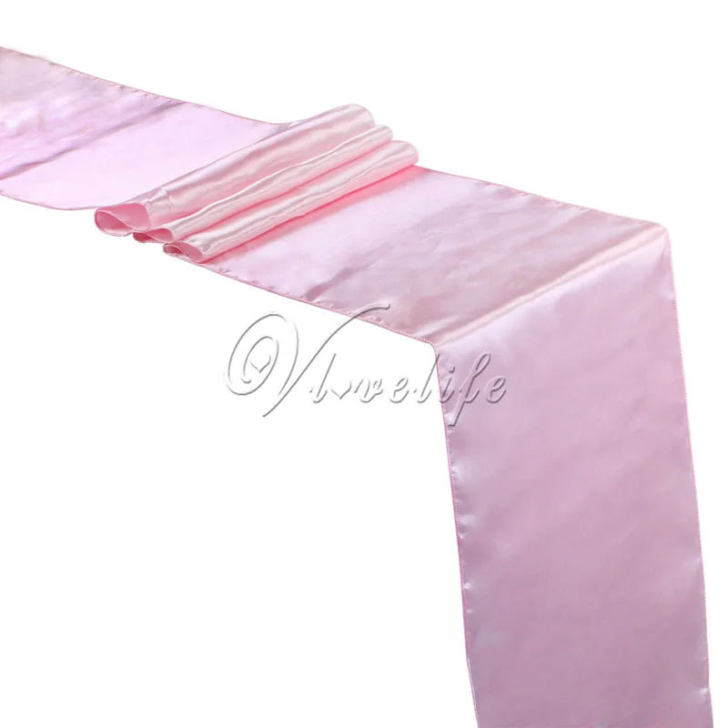 Pink satin table runner draped elegantly for weddings and events
