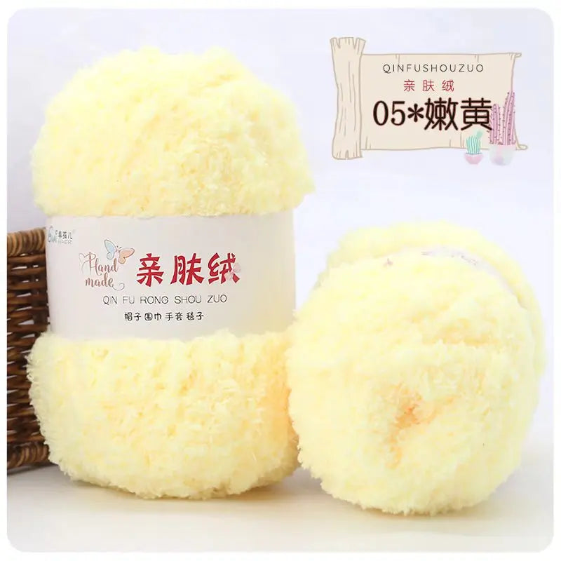 A display of yellow soft coral velvet yarn balls for crafting, packaged with branding and wooden sticks.