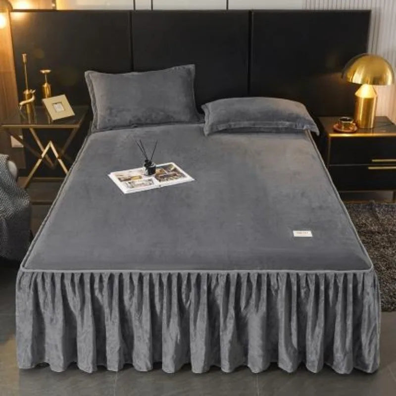 A thick gray milk velvet bed skirt with a ruffled hem is displayed on a bed.