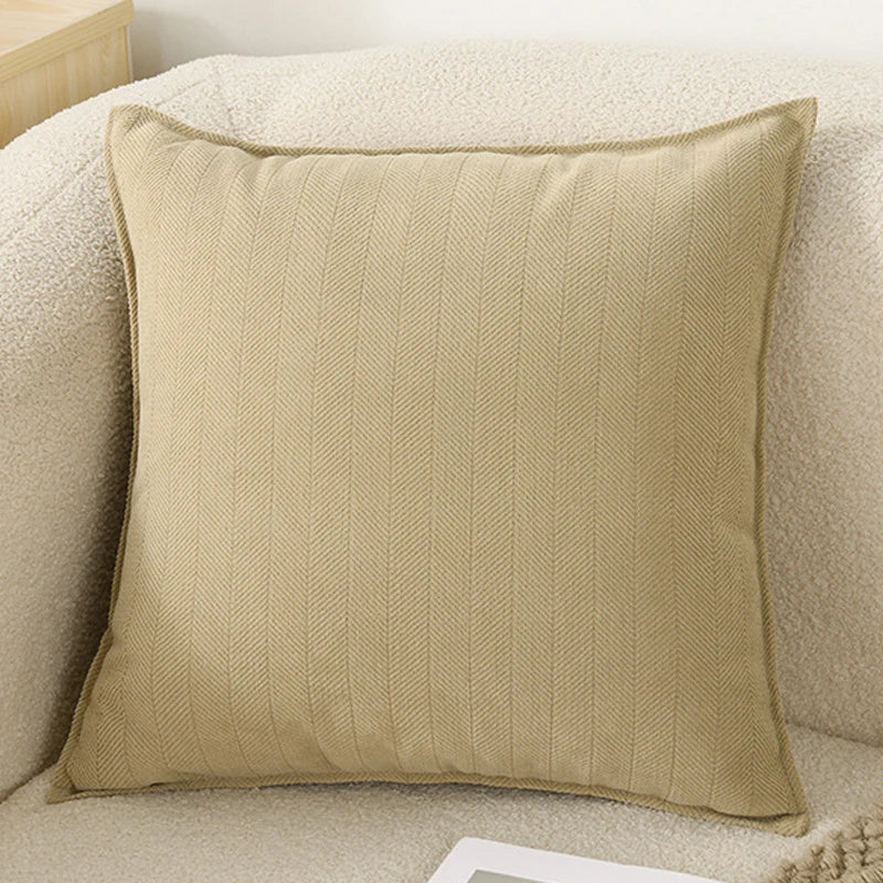 A beige chenille throw pillow cover with a vertical ribbed texture resting on a light-colored sofa.