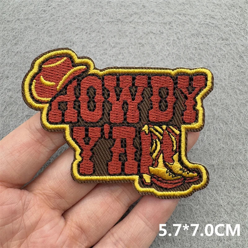An embroidered patch featuring the text HOWDY YALL in a western style with a cowboy hat design.