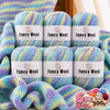 A set of six balls of fancy wool yarn in various pastel gradients, displayed next to knitted fabric.
