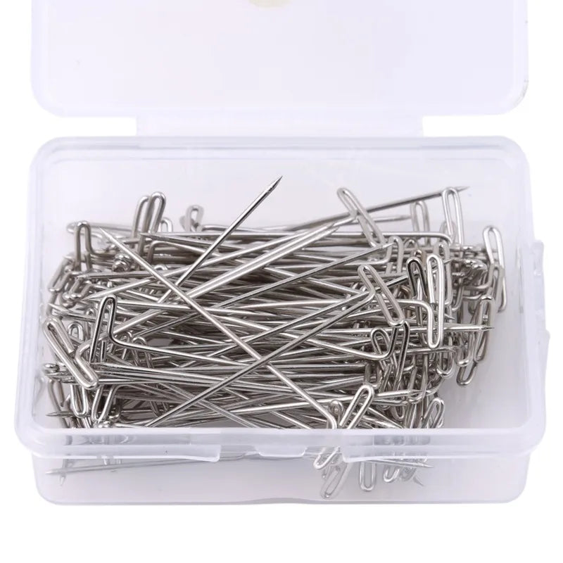 A clear plastic container holds a bundle of stainless steel T-pins for wig making or knitting.