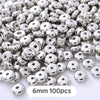 A pile of silver-toned geometric acrylic beads for jewelry making