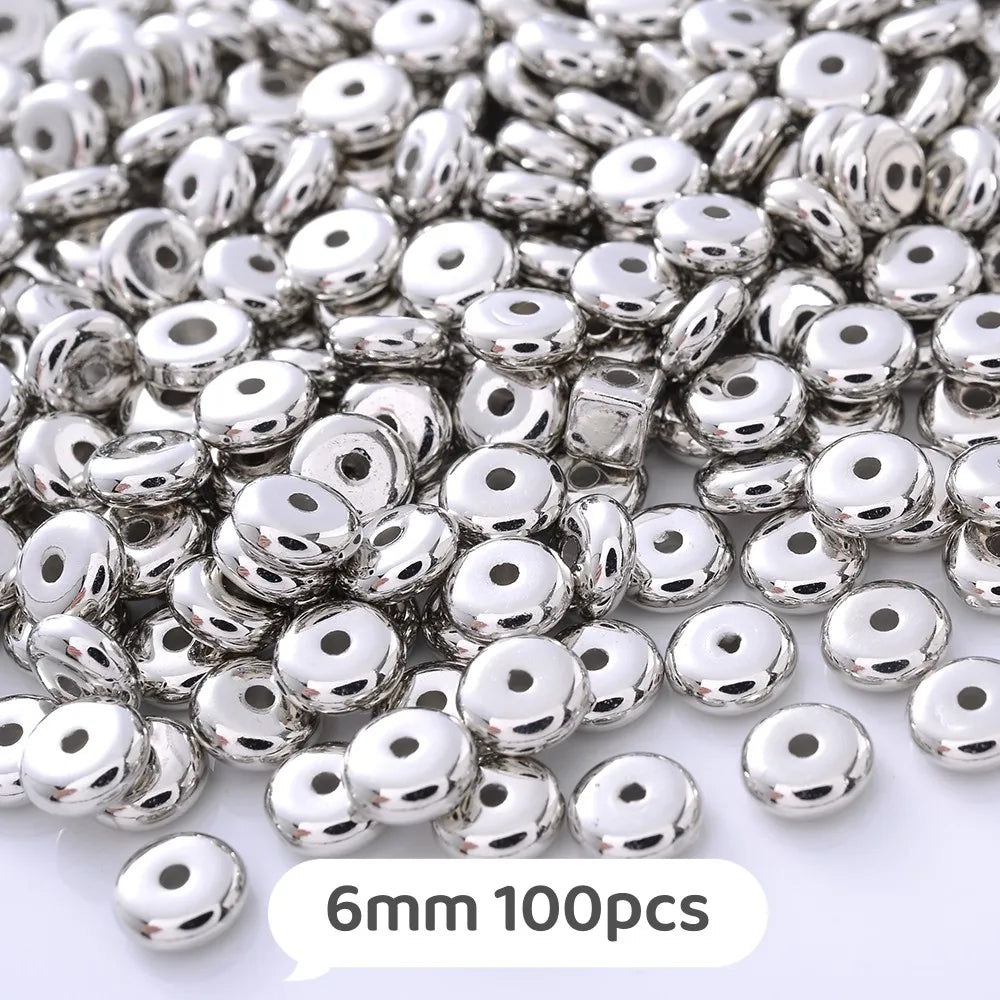 A pile of silver-toned geometric acrylic beads for jewelry making