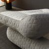 A stack of light gray quilted ergonomic contour pillows for neck and spine support.