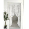 A pair of sheer white floral embroidery curtains hanging in a white frame.