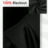 A close-up of black blackout window curtains showing the fabric texture and gathered folds.