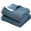 A folded blue muslin throw blanket with white trim.