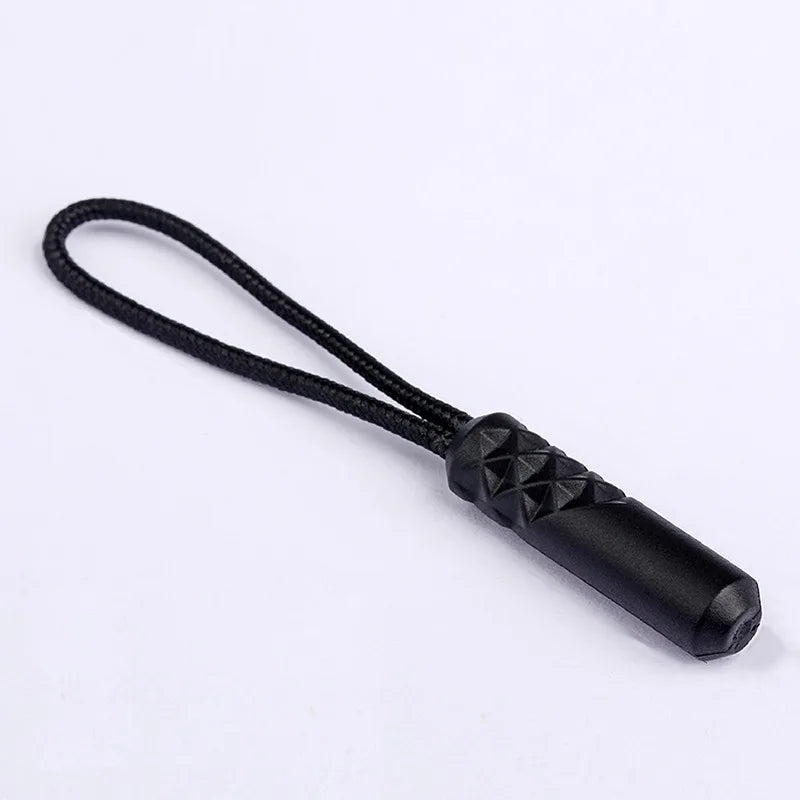 A black zipper pull replacement clip with a braided cord and a textured end is shown against a white background.