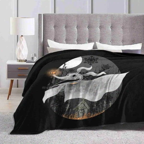 A black microfiber throw blanket featuring a large crescent moon and silhouette design on a light gray bed.