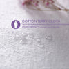 Close-up of a white cotton terry cloth fabric showing a high-density texture and small water droplets.