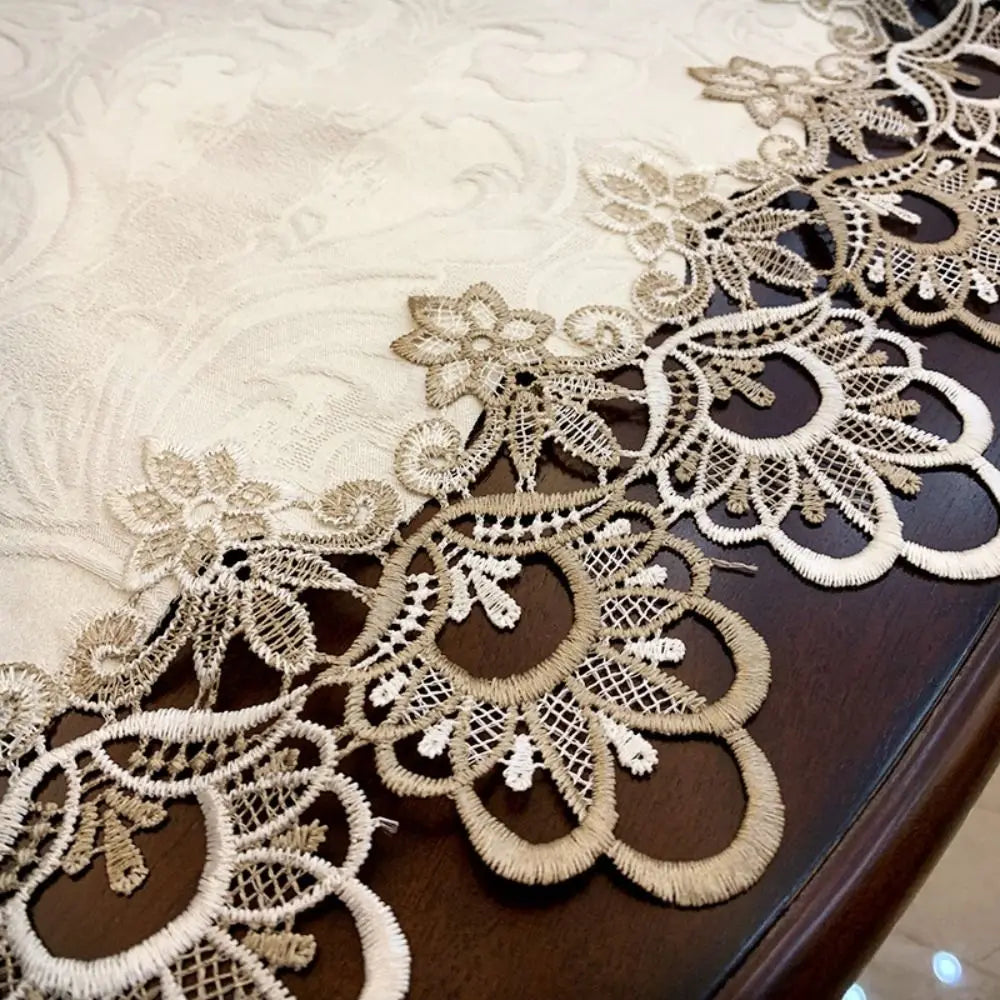 Elegant lace trim on a beige tablecloth draped over a dark wooden table.