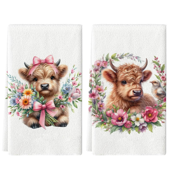 A set of two white kitchen towels featuring watercolor illustrations of adorable baby goats surrounded by floral clusters.