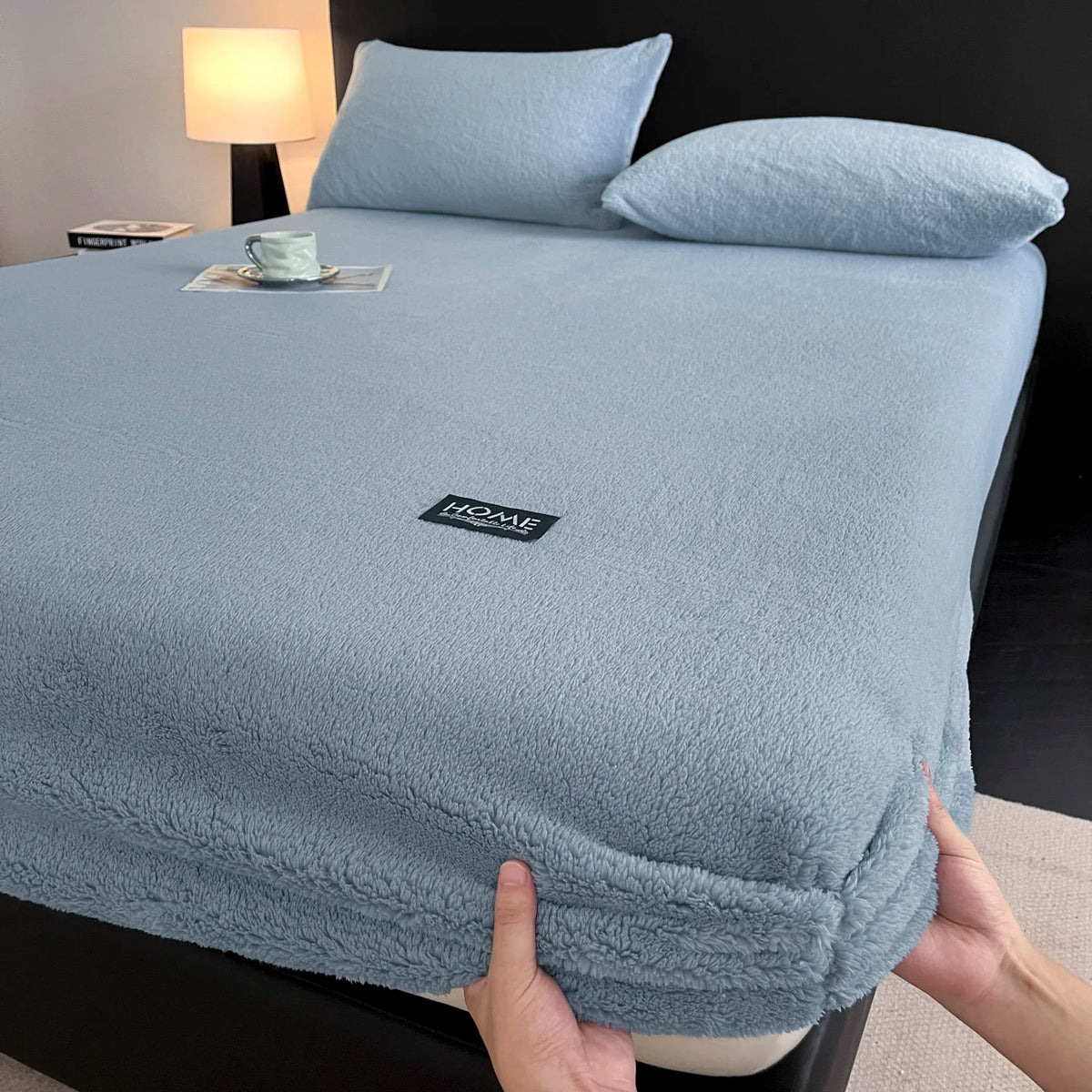 A light blue plush jacquard mattress cover is shown on a bed, with a hand touching the fabric.