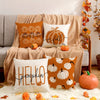 A collection of vintage autumn pumpkin pillow covers in orange, white, and brown tones displayed on a sofa.