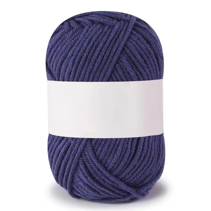 A ball of dark blue soft milk cotton knitting yarn with a white band wrapped around the center.