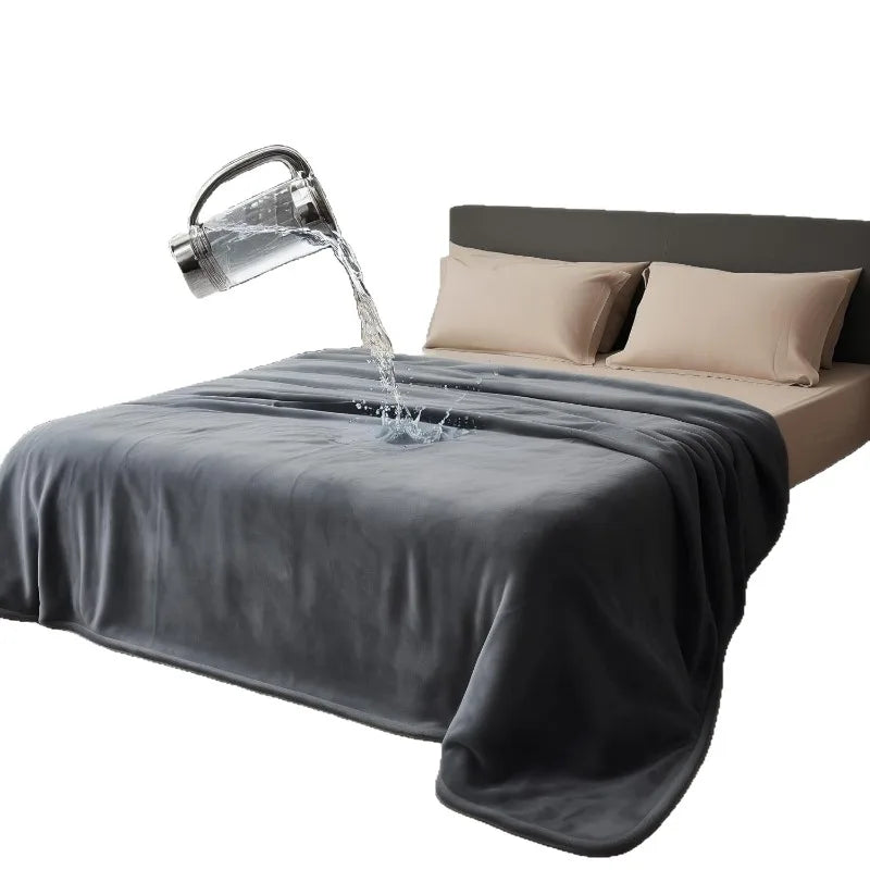 A dark gray flannel blanket is being watered by a metal pitcher, draped over a bed.