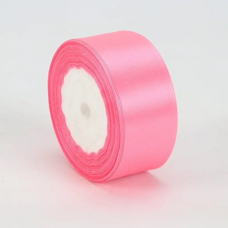 A roll of bright pink satin ribbon measuring 4cm for crafts and gift wrapping.