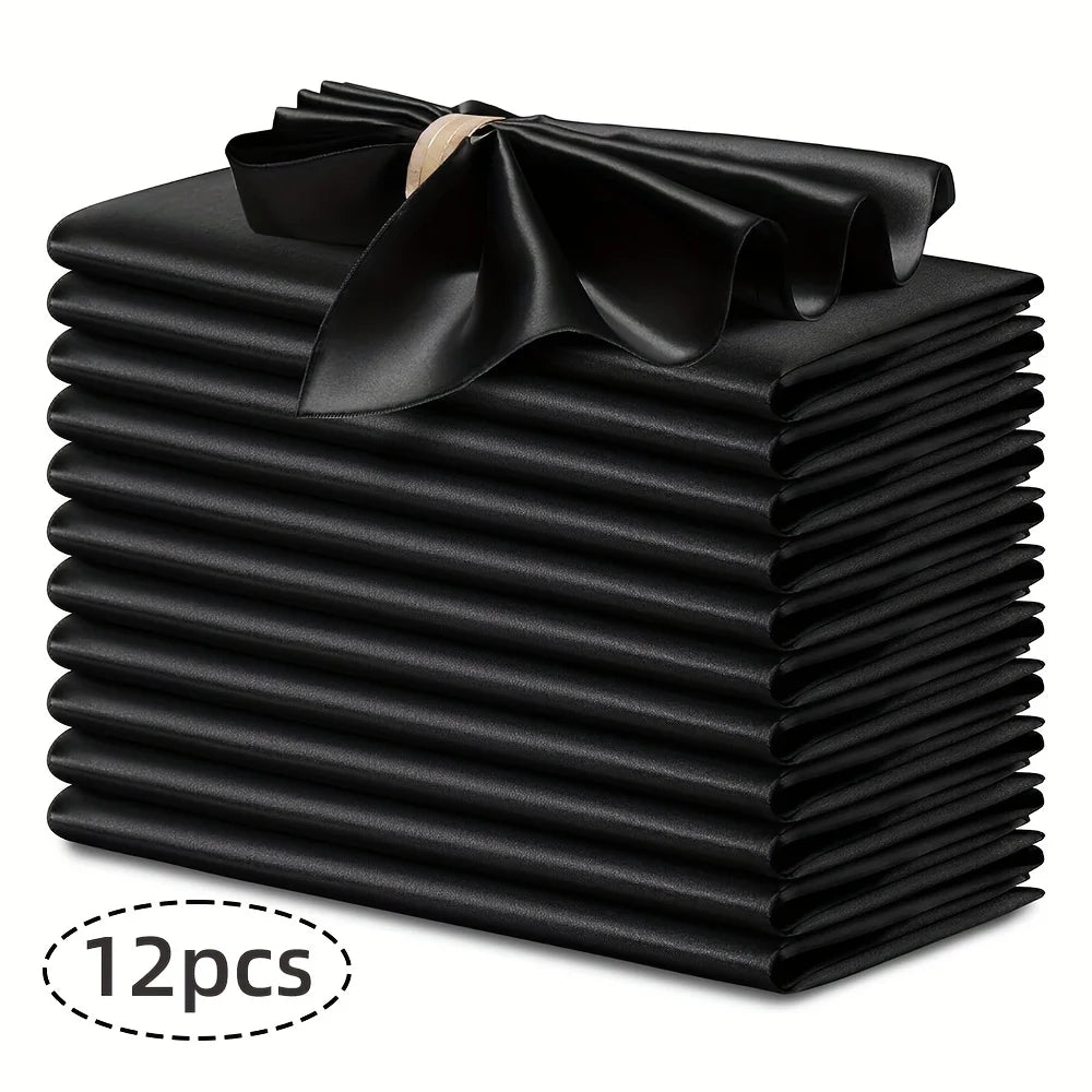 A stack of twelve black silky satin dinner napkins with a decorative bow on top.