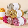 A stack of metallic gold and rose gold fabric strip yarn balls for crochet and DIY crafts.