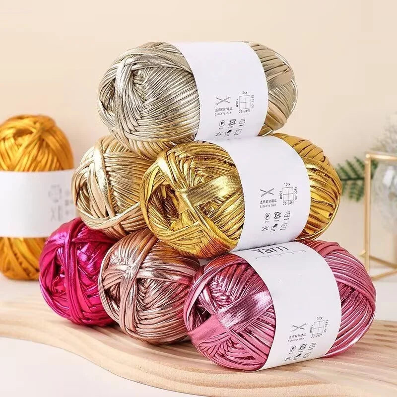 A stack of metallic gold and rose gold fabric strip yarn balls for crochet and DIY crafts.