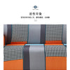 A close-up view of a sofa cover featuring geometric patterns in black, white, gray, and orange tones.