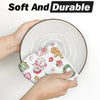 A hand holds a festive pink snowman Christmas kitchen towel set on a white plate.