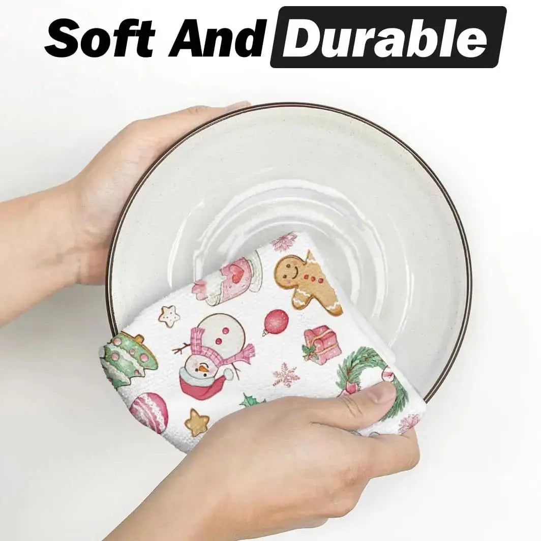 A hand holds a festive pink snowman Christmas kitchen towel set on a white plate.