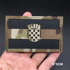 A rectangular tactical flag patch featuring a camouflage background and a central checkered emblem.
