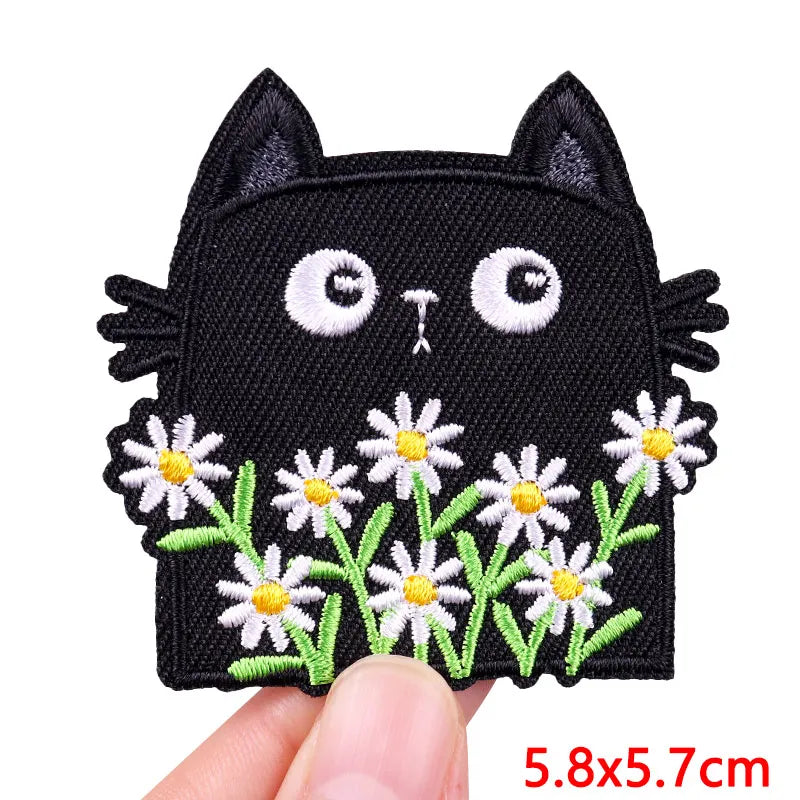 Black embroidered cat patch with white floral accents