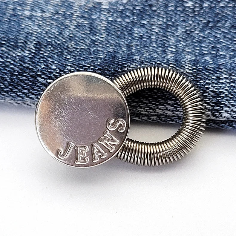 Silver extender buttons for jeans and clothing attached to a denim fabric background