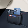 A blue smartphone is stored in a black universal car organizer storage bag placed on a car dashboard.