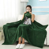 A woman models a dark green Attack on Titan Survey Corps flannel cloak with a hood draped over her shoulders.