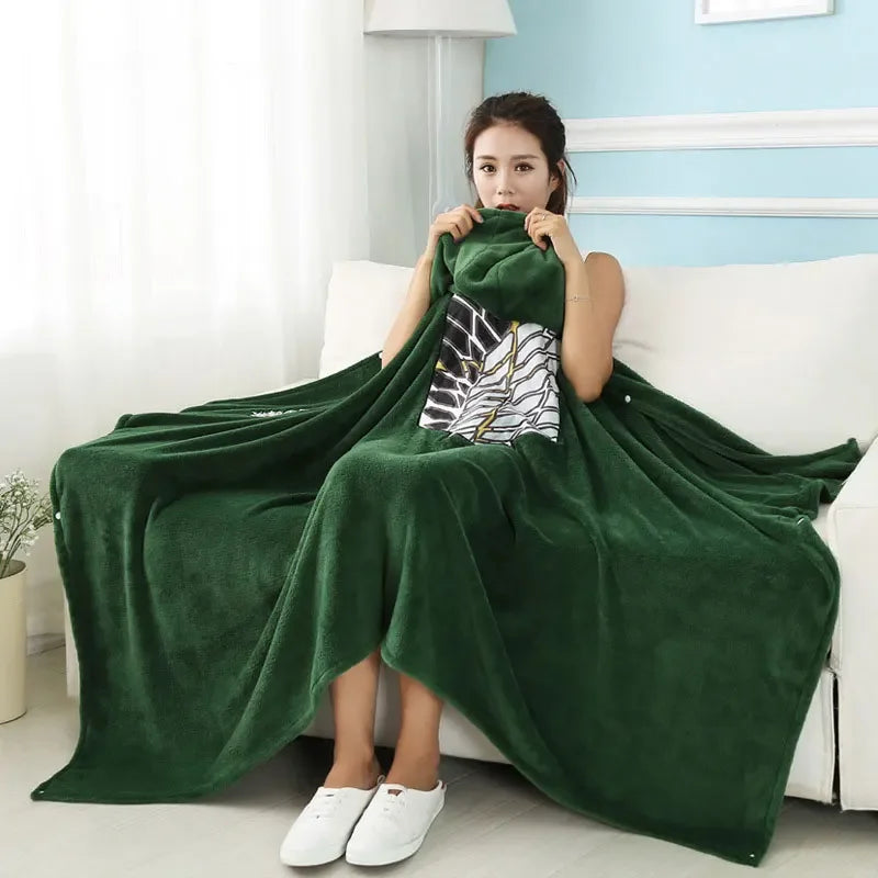 A woman models a dark green Attack on Titan Survey Corps flannel cloak with a hood draped over her shoulders.