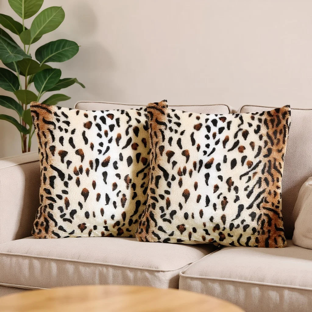 Two leopard print throw pillow covers resting on a light-colored sofa.