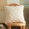 A fluffy white textured cushion resting on a light wooden stool next to a vertical ribbed screen.