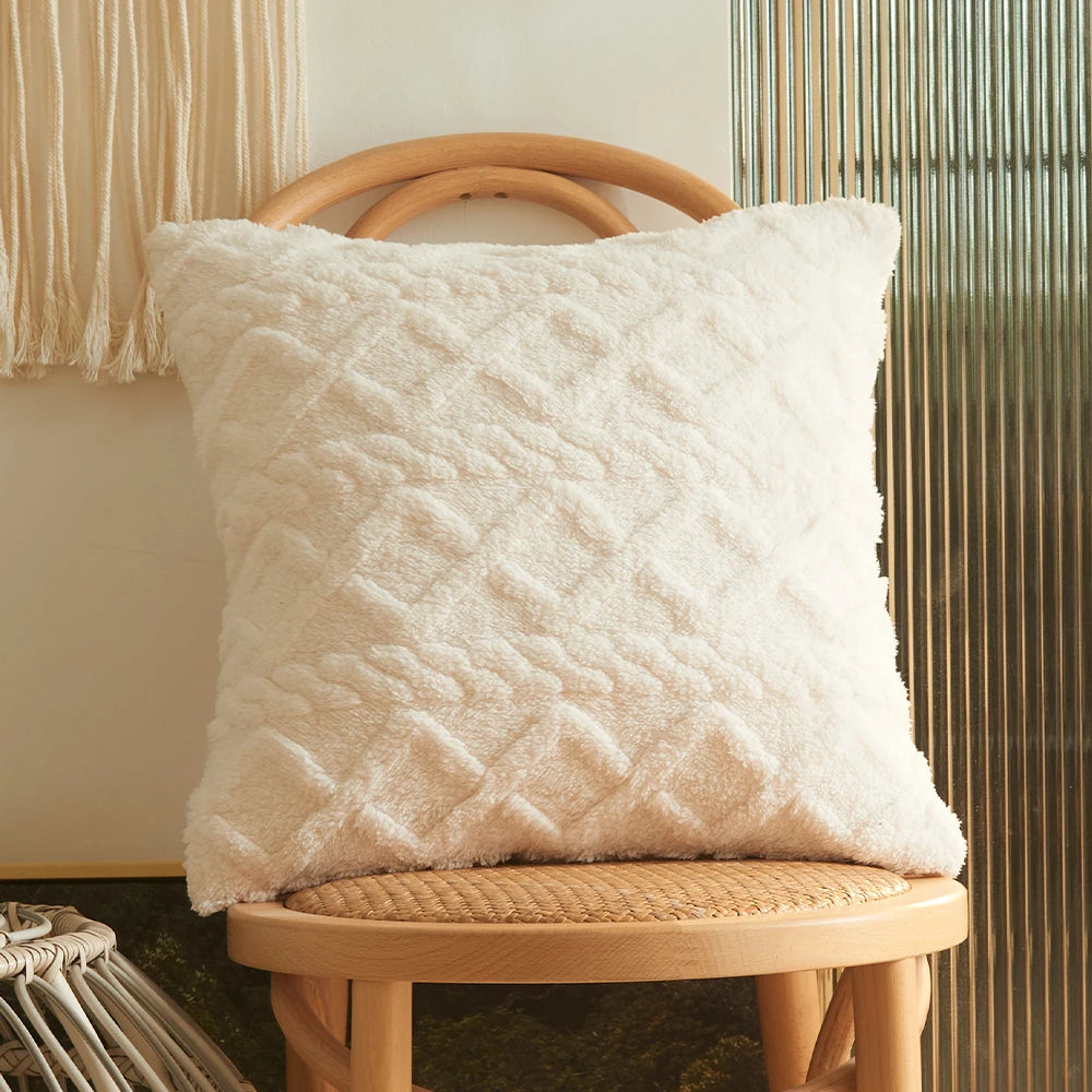 A fluffy white textured cushion resting on a light wooden stool next to a vertical ribbed screen.