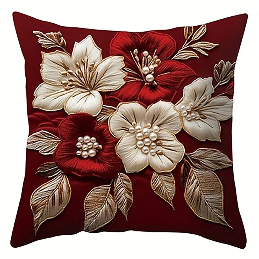 A deep red pillow cover featuring embroidered white and red floral designs.