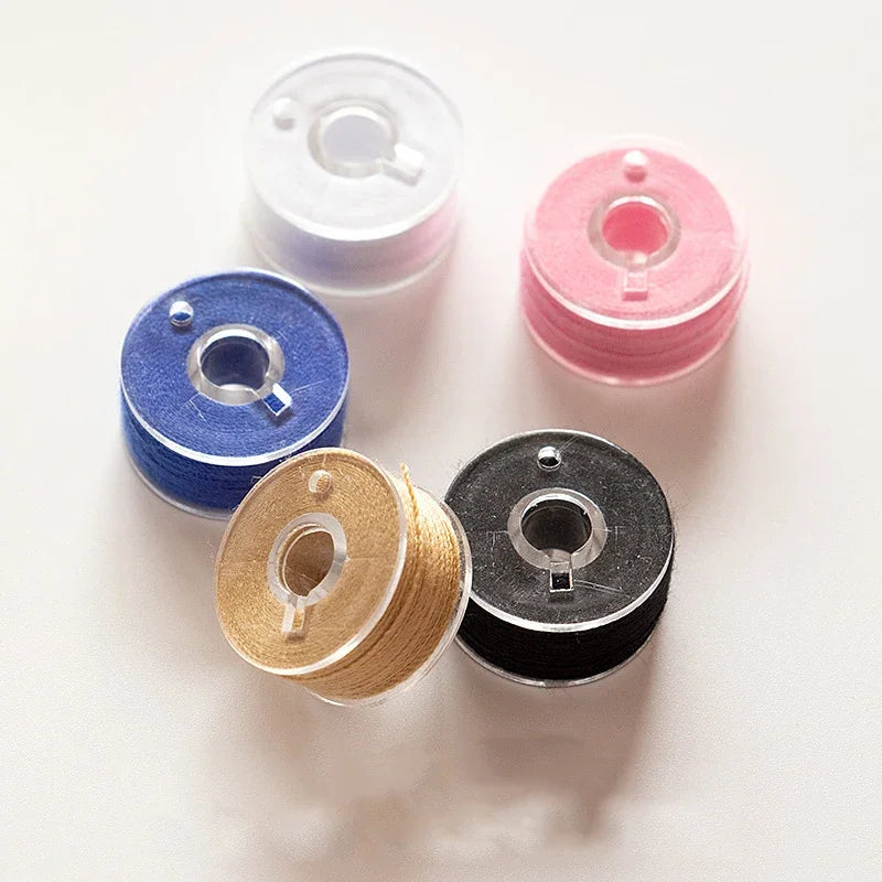 Assorted embroidery sewing threads in various colors including white, pink, blue, and gold on a white background.
