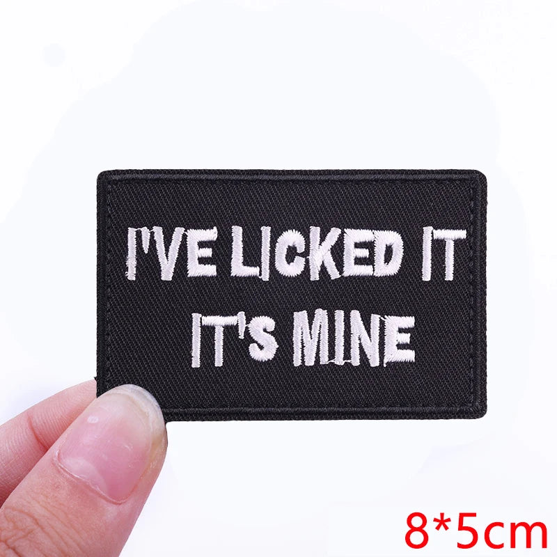 Black embroidered patch with white text that reads I've licked it it's mine