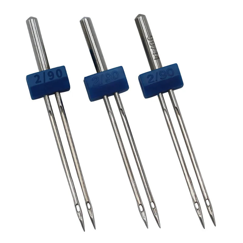 A set of three silver sewing machine needles with blue plastic handles.