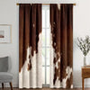 A set of two brown and white cow print curtains hanging in a doorway.