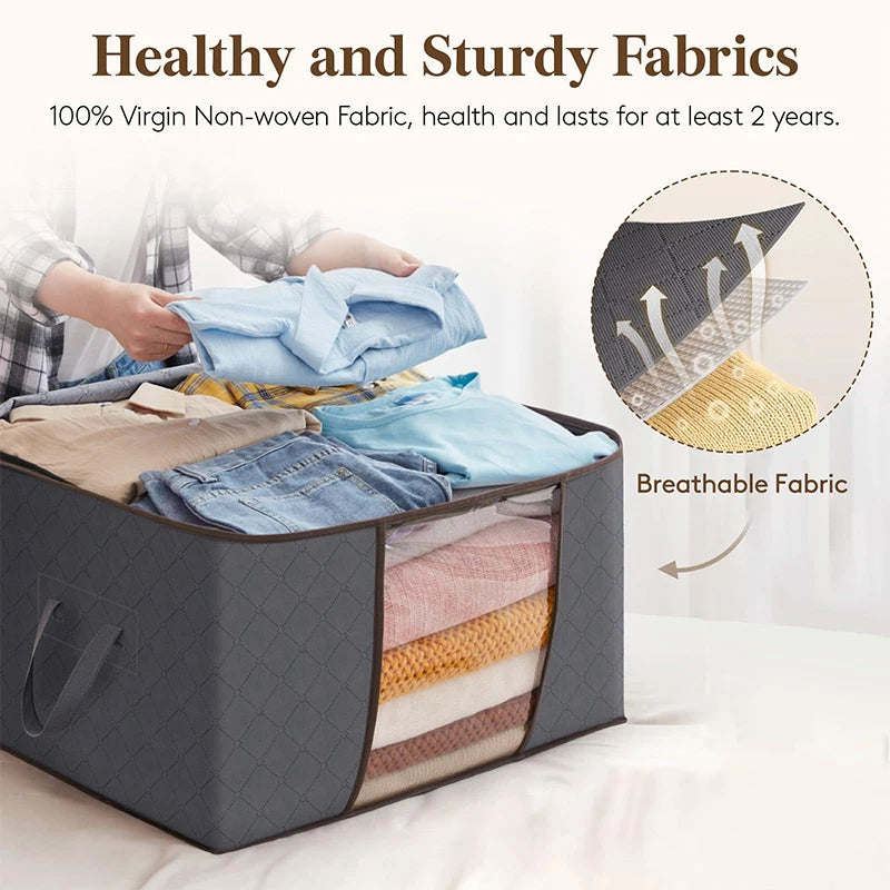 A gray foldable clothes organizer bag with a clear window showing folded blue and yellow fabrics.